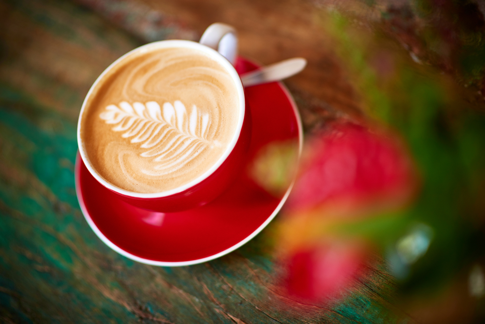 Melange in einer roten Tasse mit Blumenschmuck