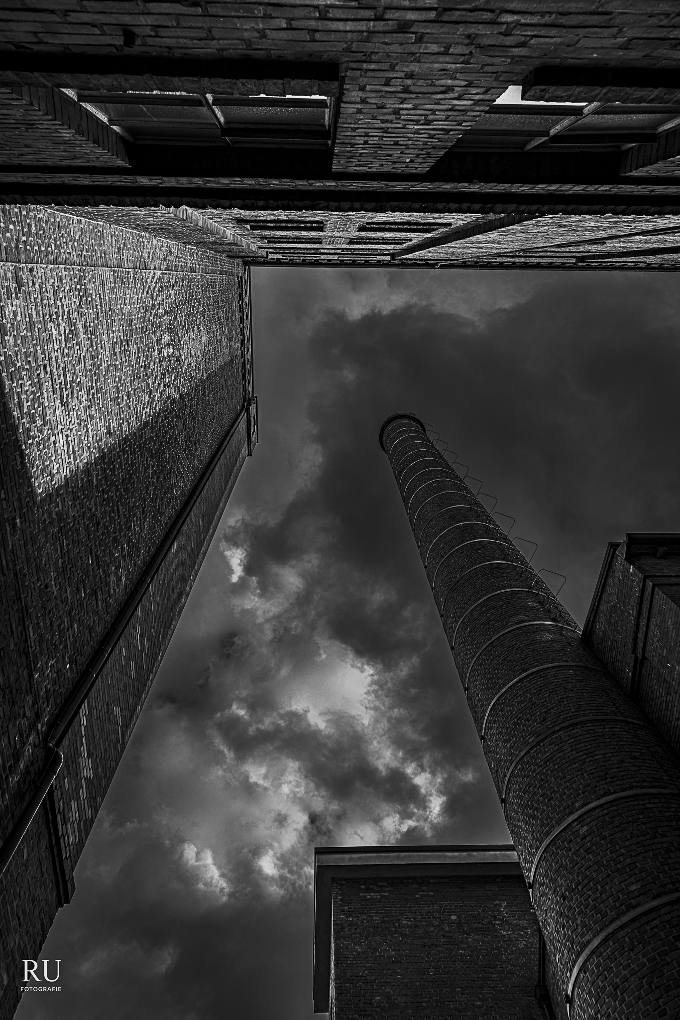 Backsteinfassaden, Industrieschornstein und dramatischer Himmel in Duisburg