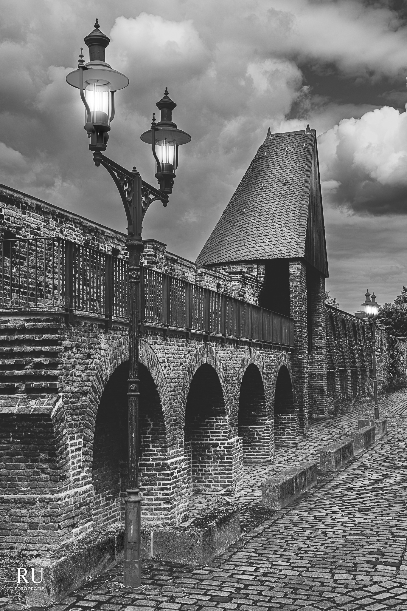 Historische Duisburger Stadtmauer mit Laternen in Schwarz-Weiß